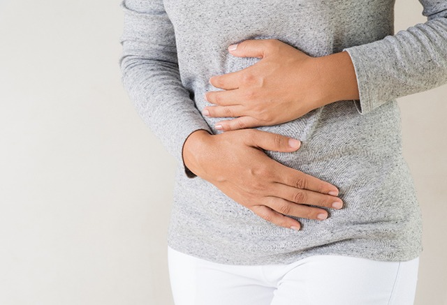 woman holding stomach 