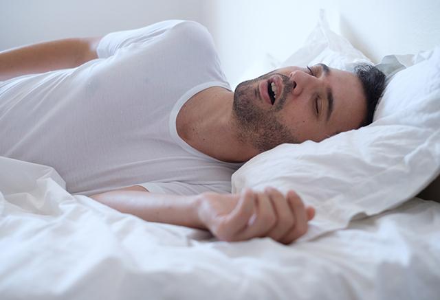 man snoring in bed 