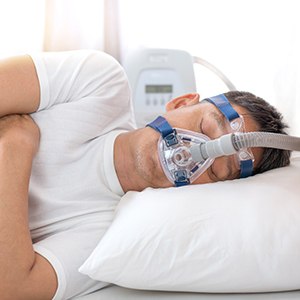 man sleeping with CPAP machine
