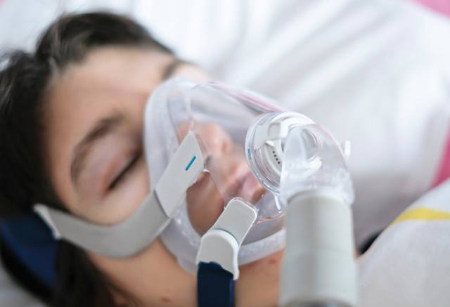 a man using a CPAP nasal mask for sleep apnea