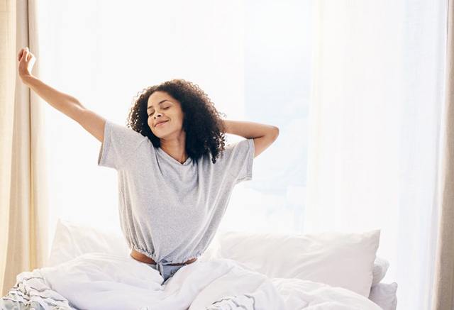 a woman waking up rested and smiling