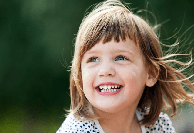 a child smiling comfortably after undergoing lip/tongue-tie treatment