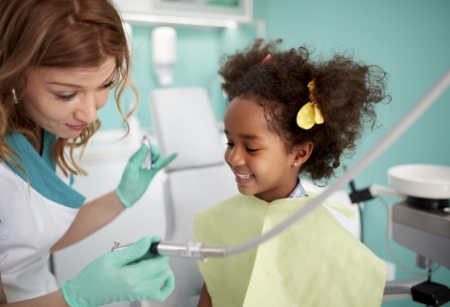 Dentist treating child following lip and tongue tie release