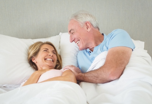 Man and woman waking feeling rested thanks to sleep apnea therapy