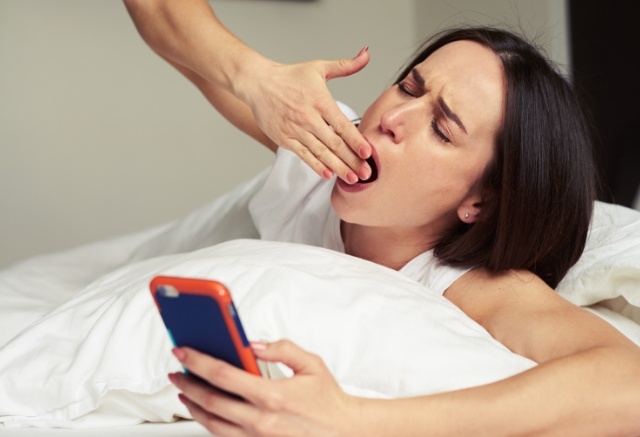 Exhausted woman experiencing sleep apnea symptoms