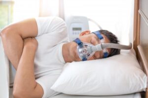 Man sleeping with CPAP machine. 